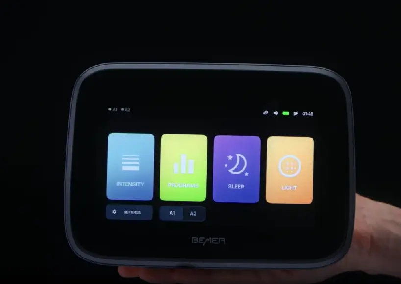 Hand holding modern therapy device with colorful touch screen display.