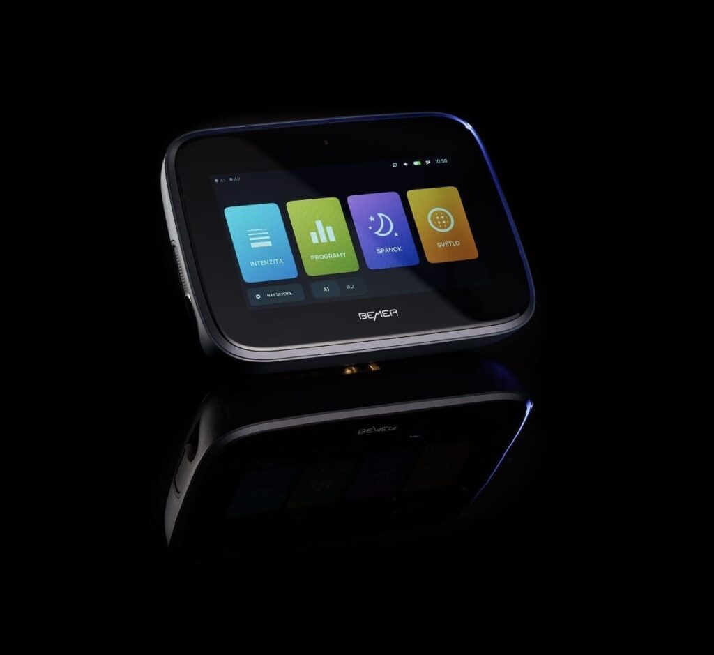 Modern touch screen medical device with colorful interface on reflective black surface.